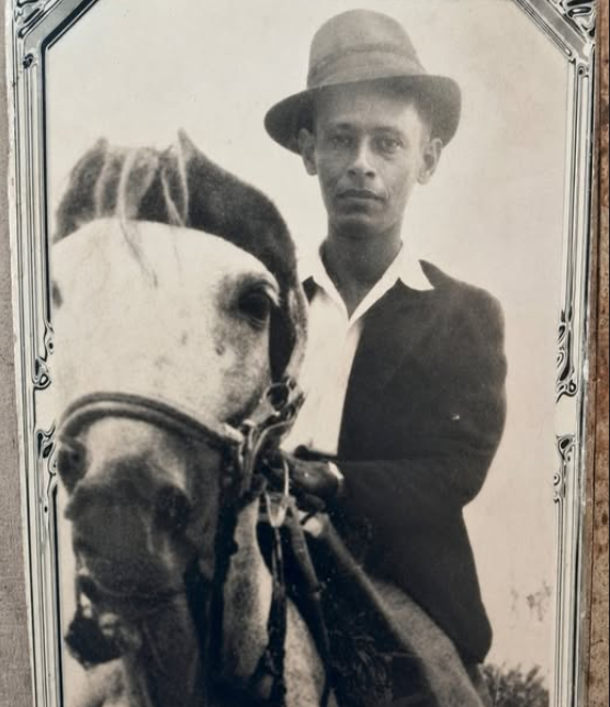 Retrato de Tulio Bautista Vivas ('Tulio, el Comandante') junto a caballo blanco, foto sepia de época